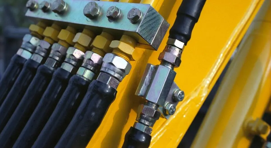 A close up of the hose and coupler on a yellow machine.